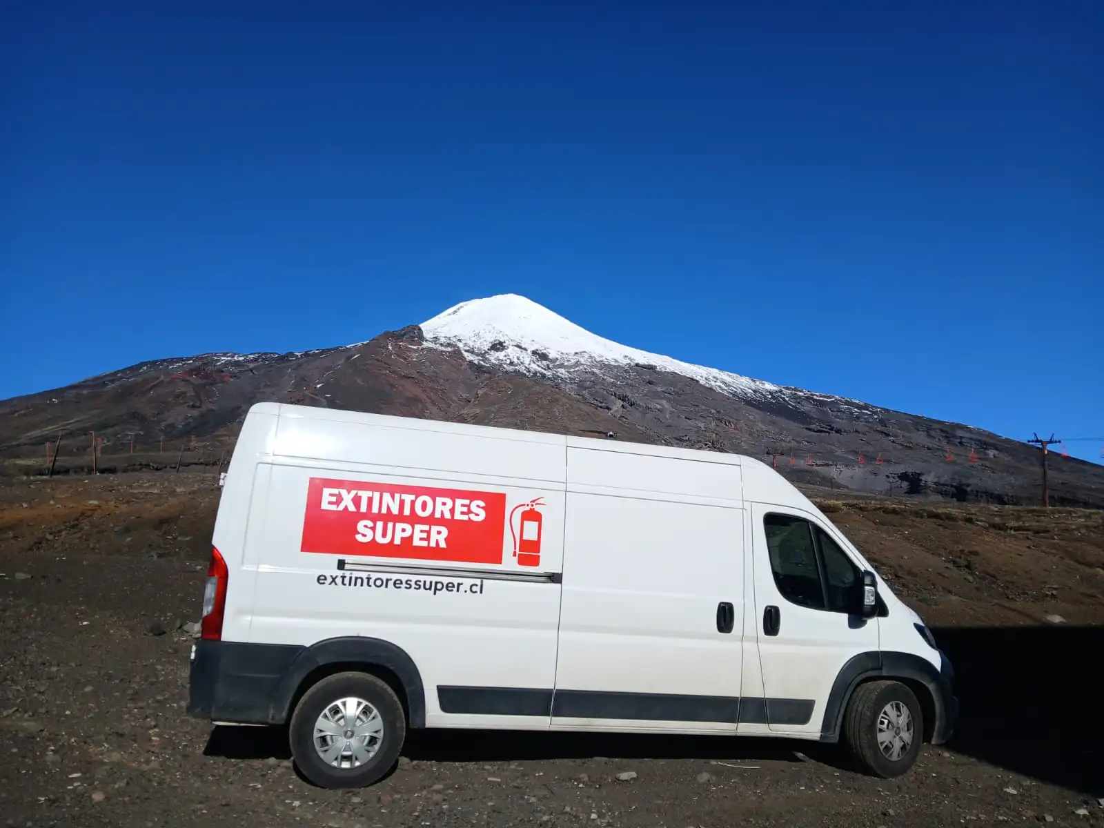 Furgón de Extintores Súper en terreno, con un volcán nevado de La Araucanía al fondo